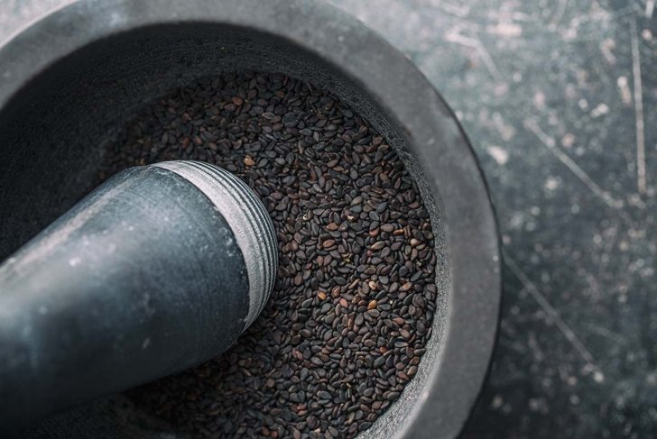 Black sesame seeds. Healthy sesame seeds in mortar. Top view.