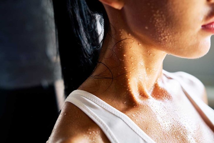 Close up shoulders and neck of a beautiful sporty girl in drop of sweat on skin after workout